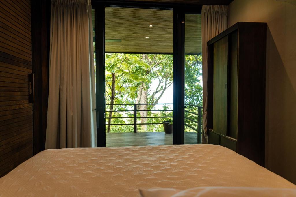 a bedroom with a bed and a large window at Casa VISTA PARAISO in Santa Teresa Beach