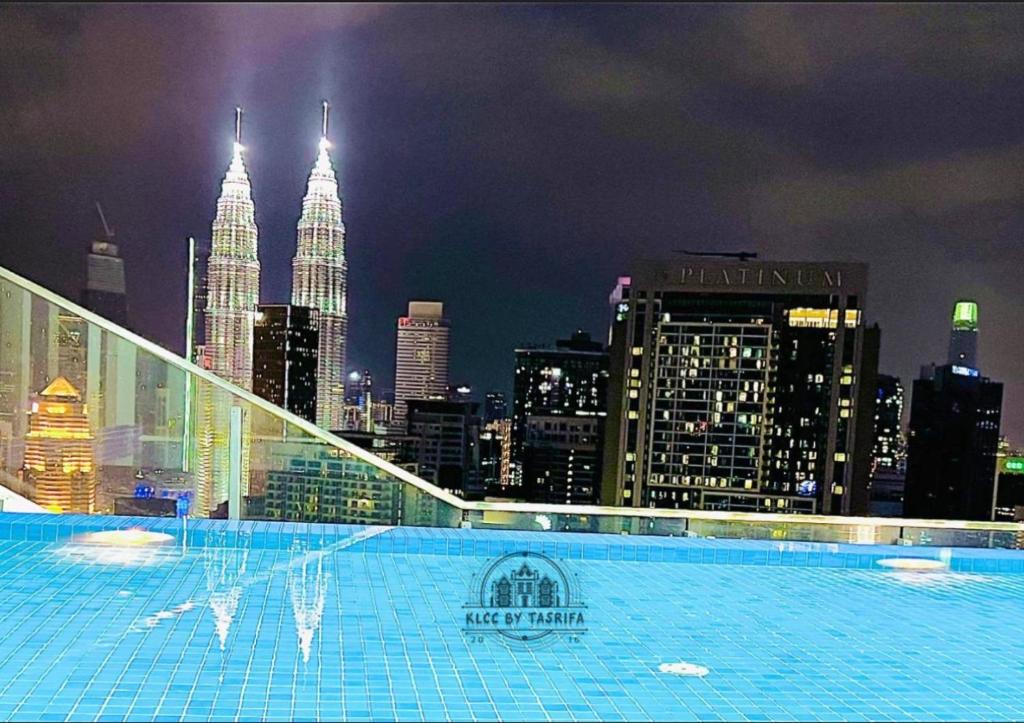 Una piscina con vista a la ciudad por la noche. en The Luxe Infinitum KLCC By Skyscrapers, en Kuala Lumpur