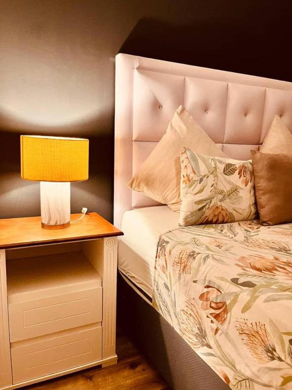 een bed met een gele lamp op een nachtkastje bij MORRO do MOCO in Windhoek