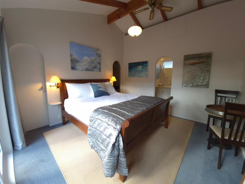 a bedroom with a bed and a table in a room at Waikawa Retreat in Waikawa