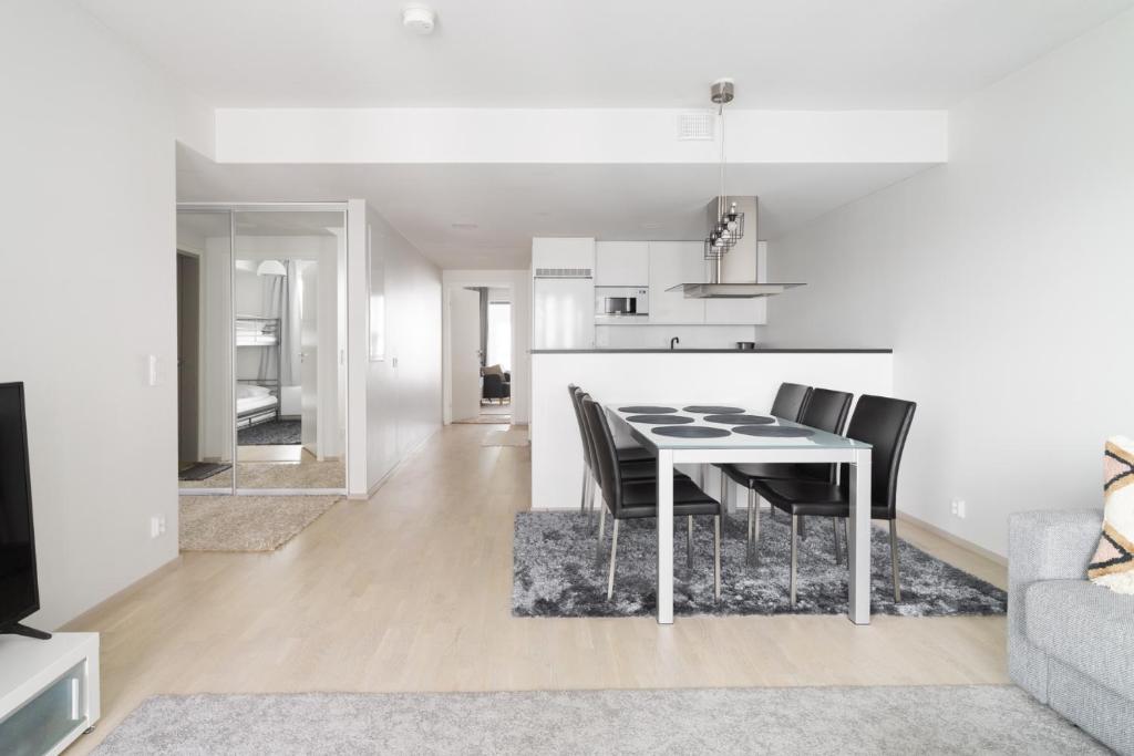 a kitchen and dining room with a table and chairs at Modern 2BR apartment W 2 balconies, Metro, Helsinki 15min in Espoo