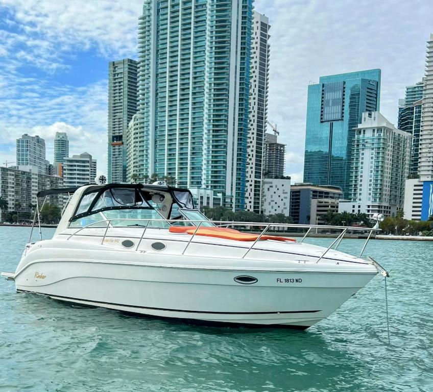 una barca bianca in acqua di fronte a una città di Party On The Seas a Miami