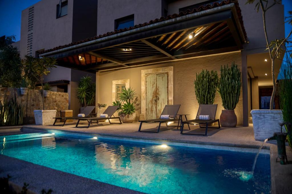 einen Pool mit Stühlen neben einem Gebäude in der Unterkunft Mezquite by Viadora in San Miguel de Allende