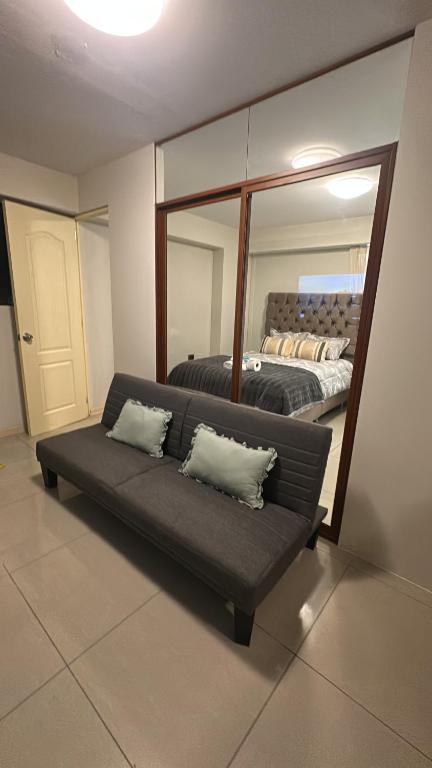 a living room with a couch in front of a mirror at Sumaq kawsay in Cusco