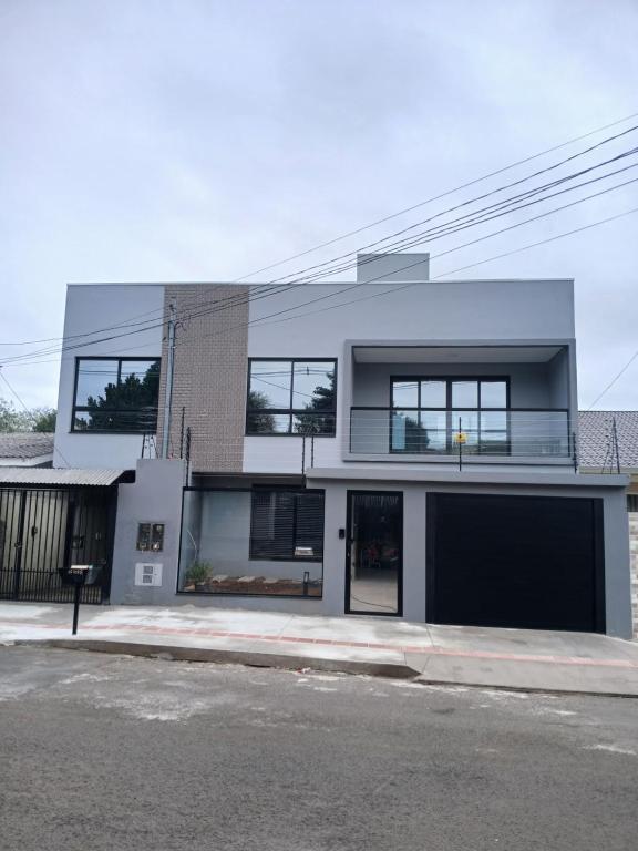 a large white building with windows on a street at StudioD in Passo Fundo