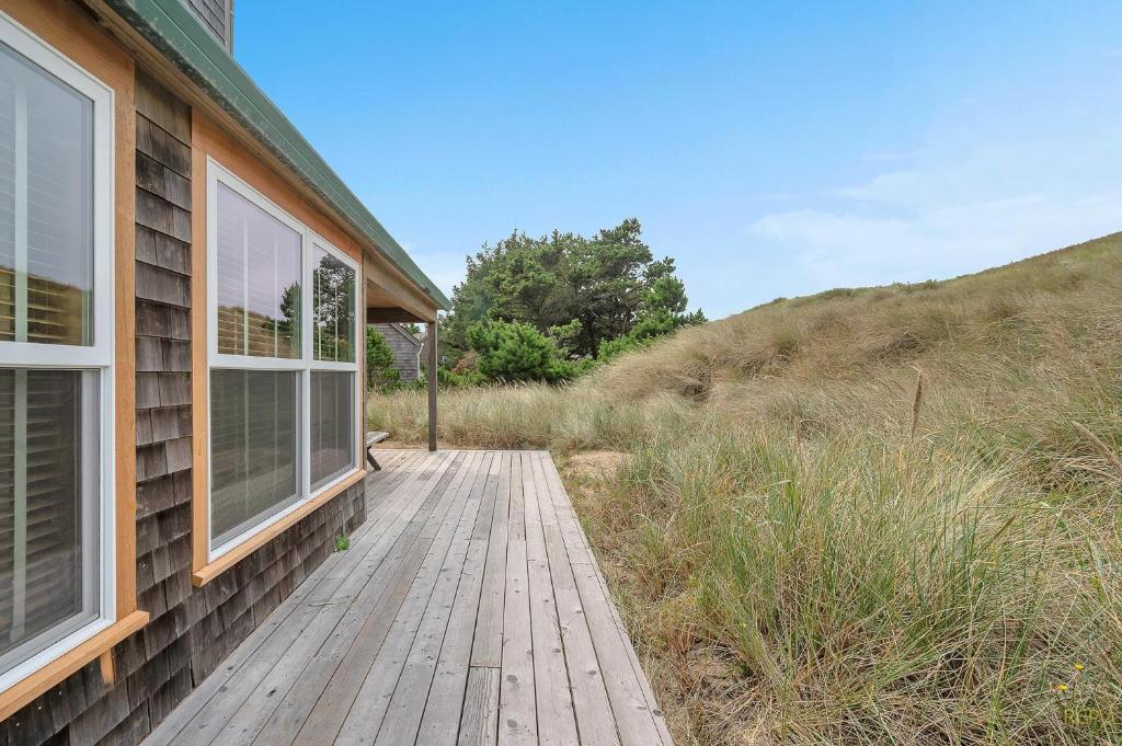 a wooden walkway next to a house with a window at The Break in Pacific City