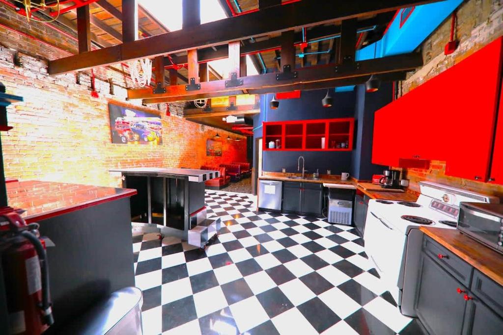 cocina grande con armarios rojos y suelo a cuadros en Printers Alley Downtown Mansion, en Nashville