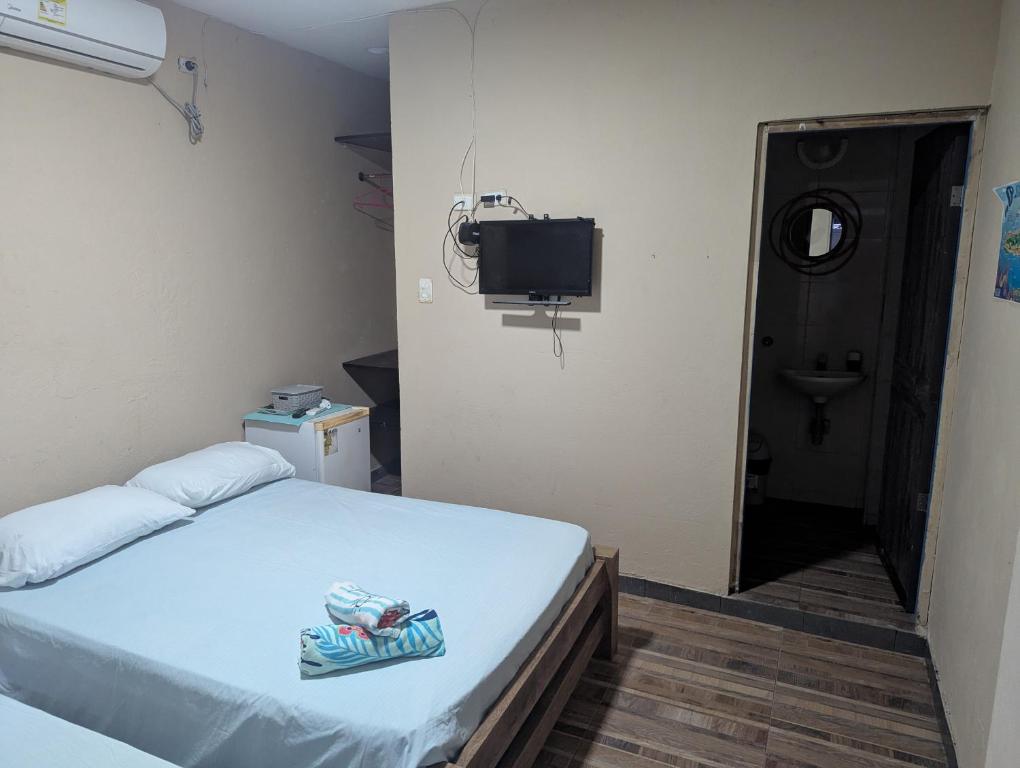 a small room with a bed and a television at Posada hossana in San Andrés