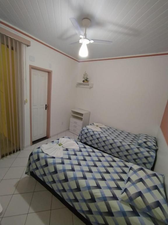 a bedroom with two beds and a ceiling fan at Kayc pousada in Amargosa