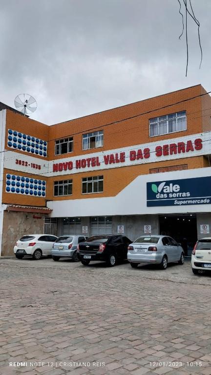a large building with cars parked in front of it at Hotel Vale Das Serras in Jacobina