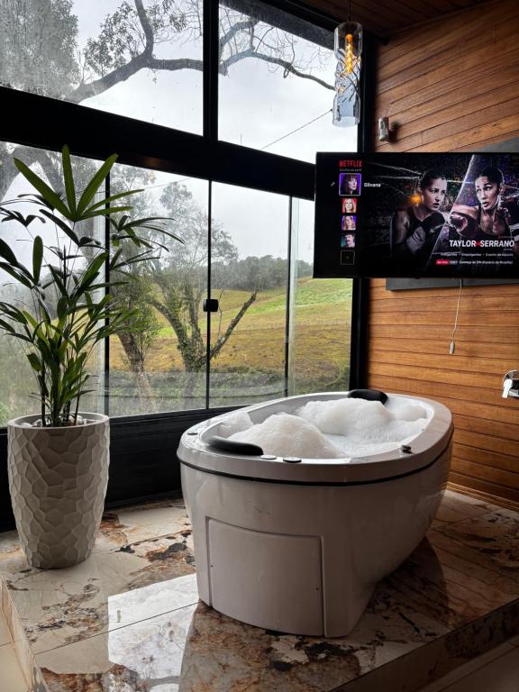 a white bath tub sitting in a room with a window at Cabana Canyon in Barracão