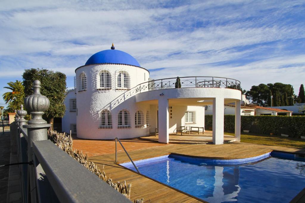 a white house with a blue dome and a swimming pool at Villa Santorini in Cambrils