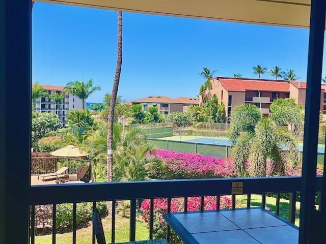 een balkon met uitzicht op een tennisbaan en palmbomen bij Maui Vista 3213 condo in Kihei