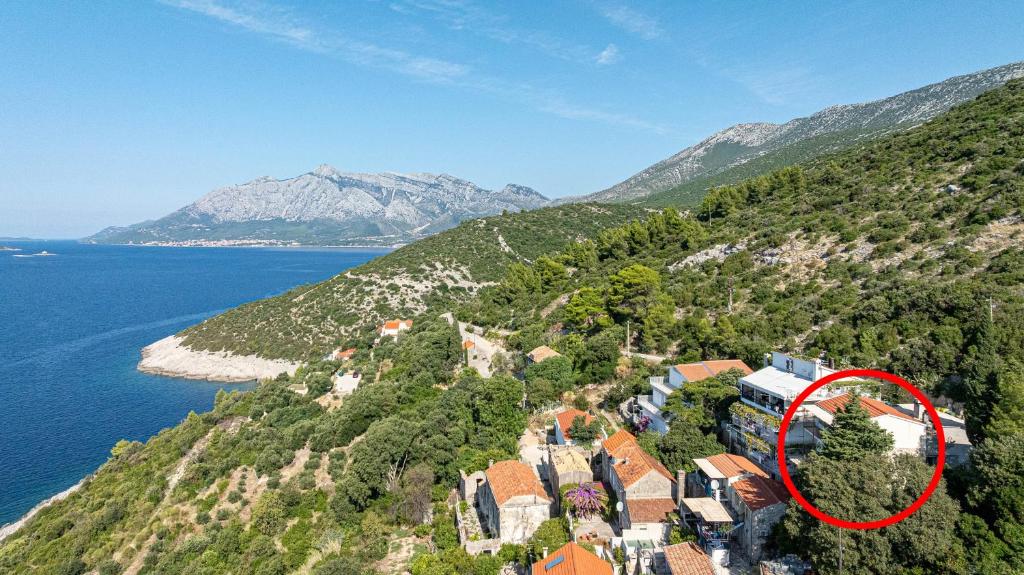 a house on a hill next to the water at Apartments with parking space Borje, Peljesac - 21496 in Orebić