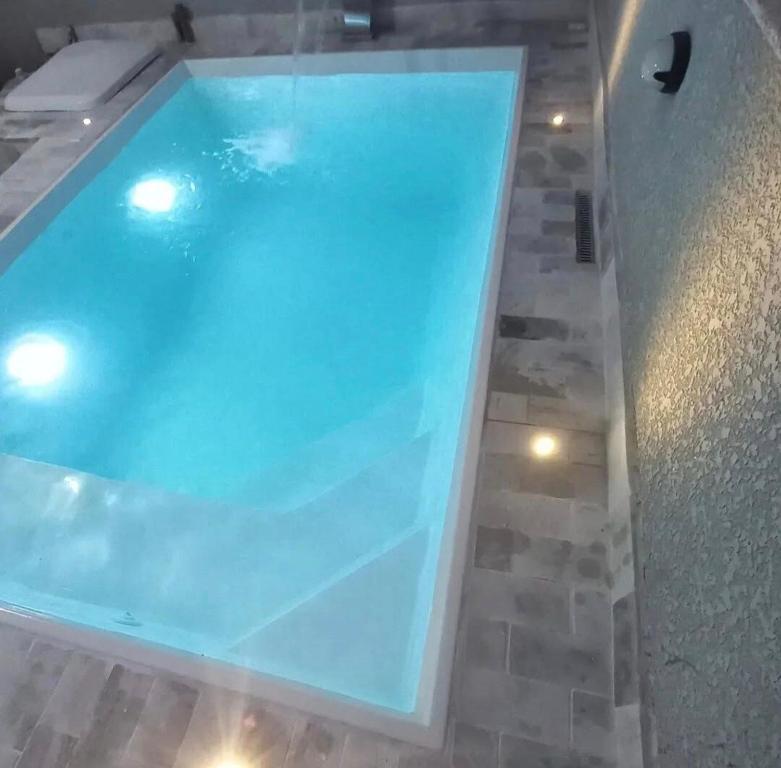 a large blue swimming pool with a tile floor at Casa com piscina! Descanso e Lazer in Itapoa