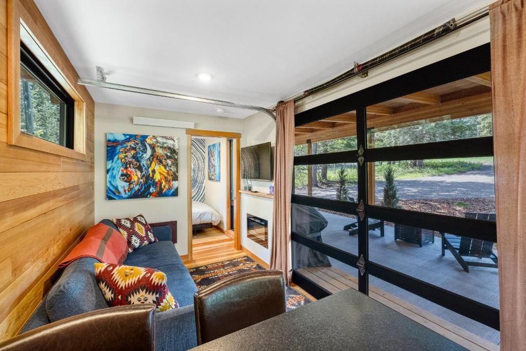 a living room with a couch and a large window at Two Pines - Unique container home w/hot tub - Downtown - Trailer Parking - Pet friendly in McCall