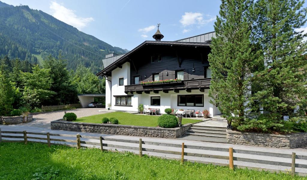 a house in the mountains with a fence at Alpin Hotel Garni Eder - Private Living in Mayrhofen