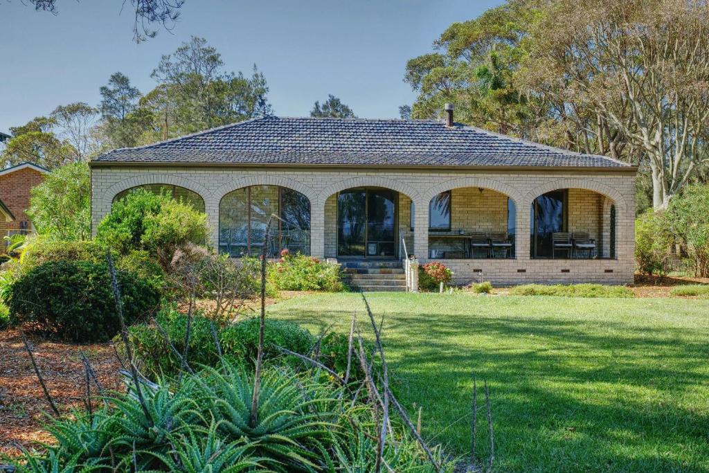 een huis met grote ramen en een tuin bij Seabreeze Arches in Callala Bay