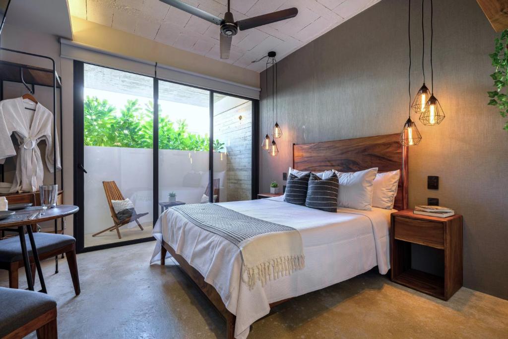 a bedroom with a large white bed and a table at The Sands Boutique Condos in Playa del Carmen