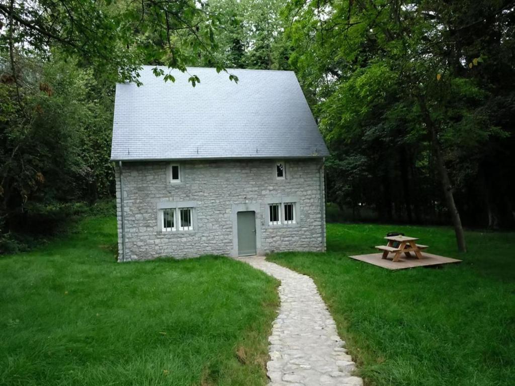 a stone building with a picnic table in front of it at 2-bedroom cottage with park and deer park in Haltinne