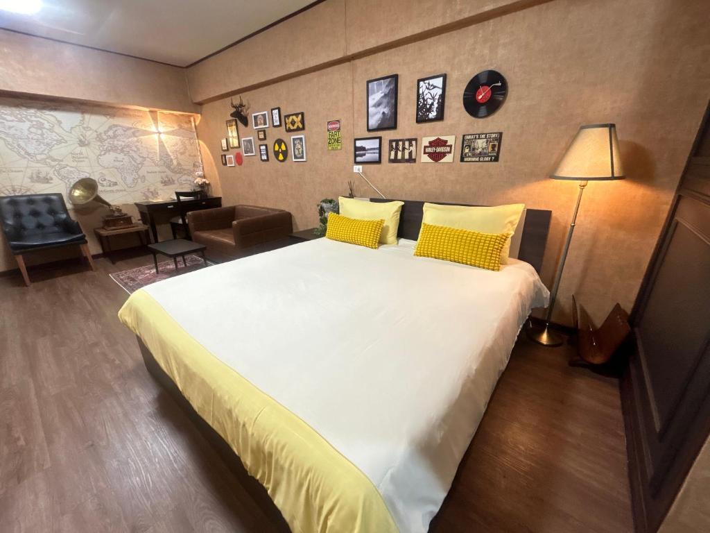 une chambre avec un grand lit blanc avec des oreillers jaunes dans l'établissement Secret Retro Vintage Building ห้องลับเรโทรในตึกวินเทจ, à Ban Song Hong