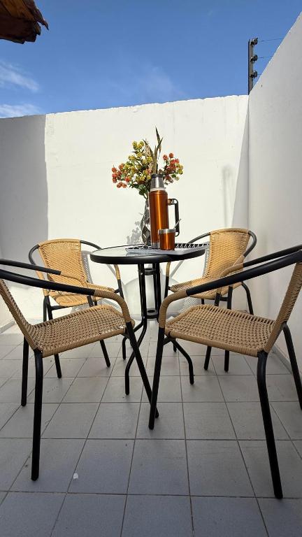 a black table with chairs and a vase on it at Increible Departamento en Ciudad de Mendoza, a metros de Parque Central y proximo a microcentro con cochera Pellegrini Apartments Parque Central in La Cieneguita