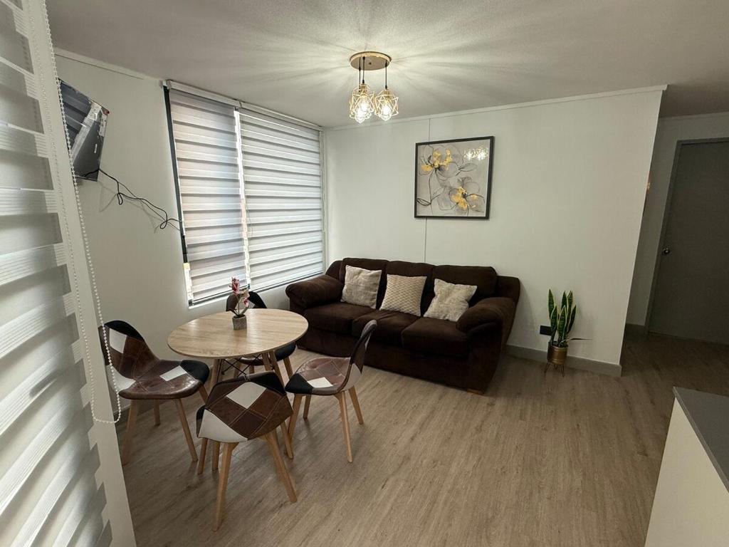 a living room with a couch and a table at Comodo y hermoso departamento en centro histórico in Santiago