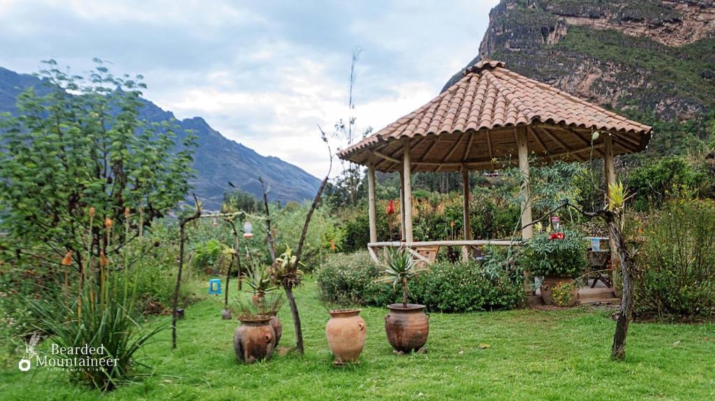a garden with a gazebo and pots in the grass at Bearded Moutaineer sacred garden & lodge in San Salvador