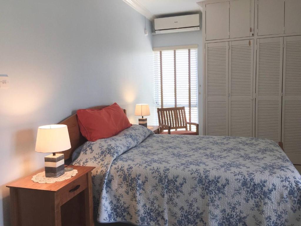 a bedroom with a bed and a table with two lamps at Modern Abbey Court Condo in New Kingston
