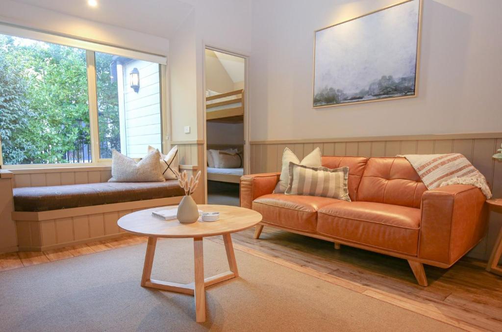 a living room with a couch and a table at Autumn Leaf Cottage 2 in Harrietville