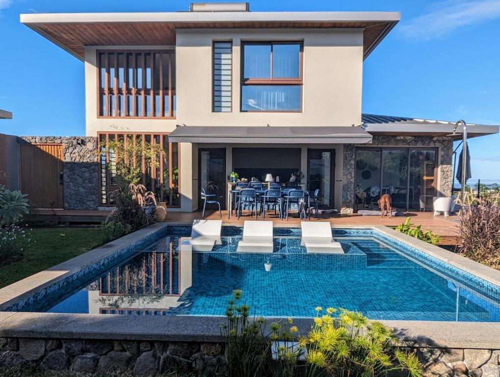 une maison avec une piscine devant une maison dans l'établissement La villa Blue Banian, à Saint-Pierre