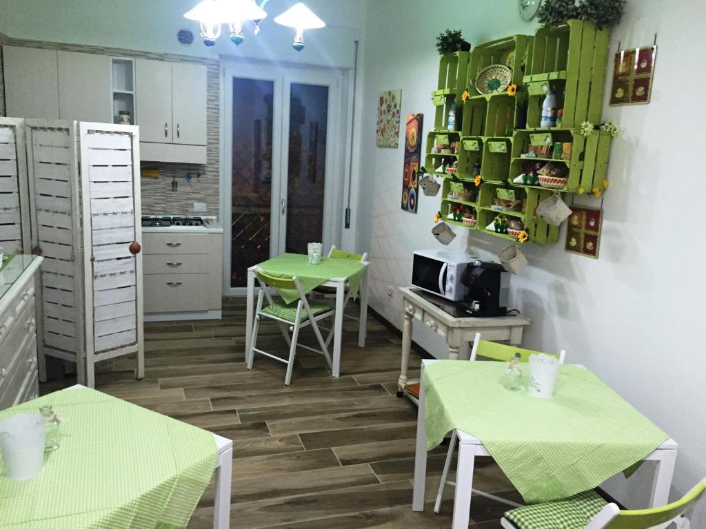 una cocina con 2 mesas y una cocina con encimeras verdes en B&B Castello, en Crotone