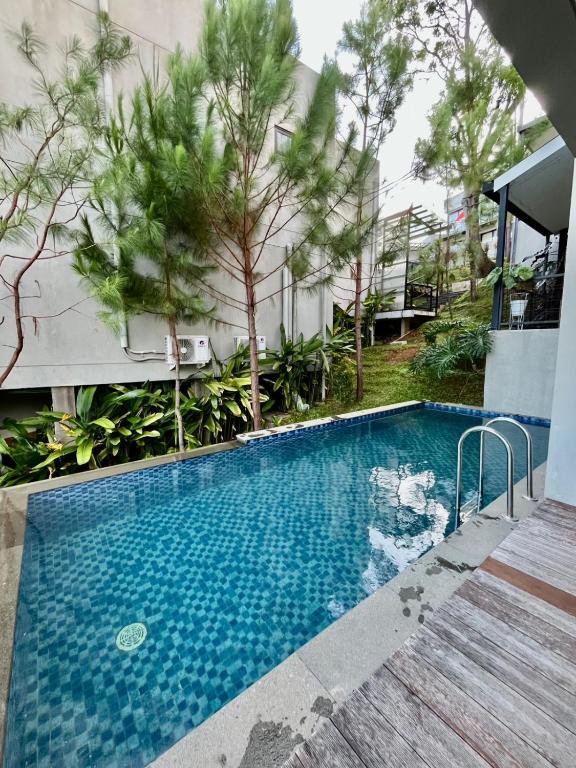 MantaakにあるVilla Vivian Dago Bandungの木の建物の前にあるスイミングプール