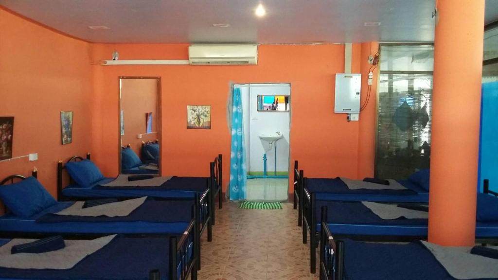 een kamer met rijen stoelen en oranje muren bij Blue Hostel in Haad Rin
