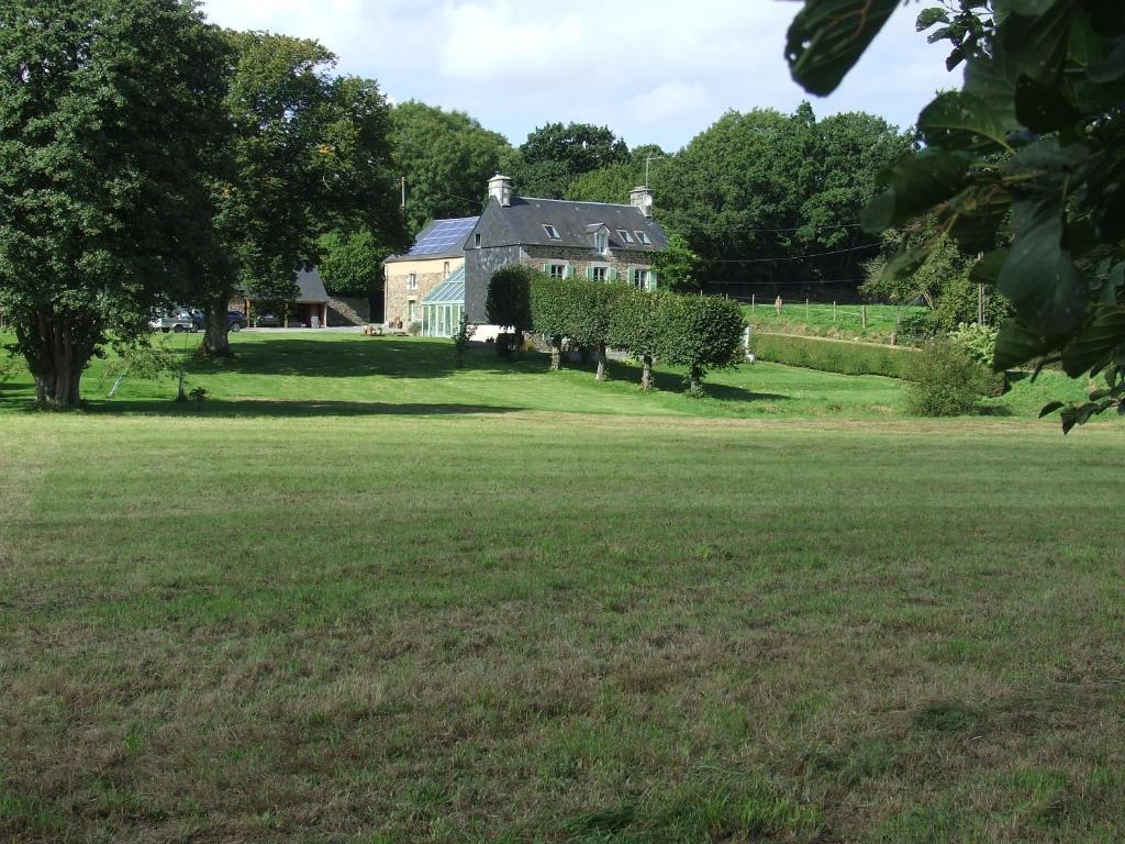 una casa en un campo con un gran patio en Le Clos du Val, en Quibou