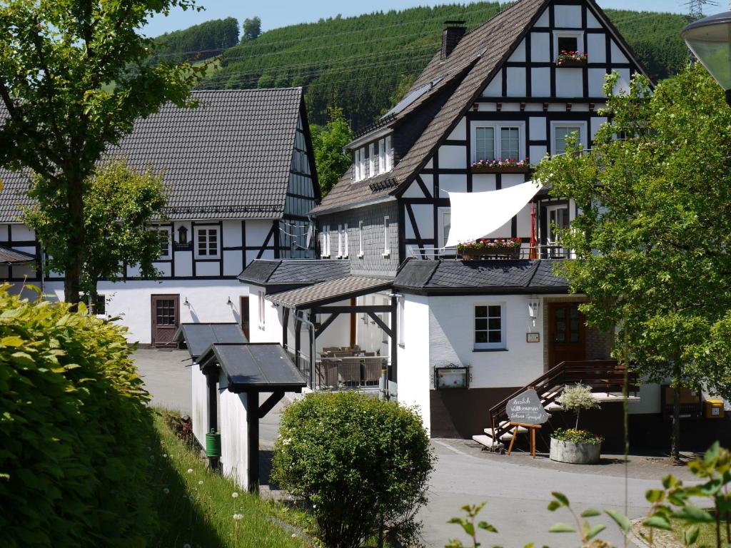 a village with black and white houses and trees at Gasthof zur Post in Schmallenberg