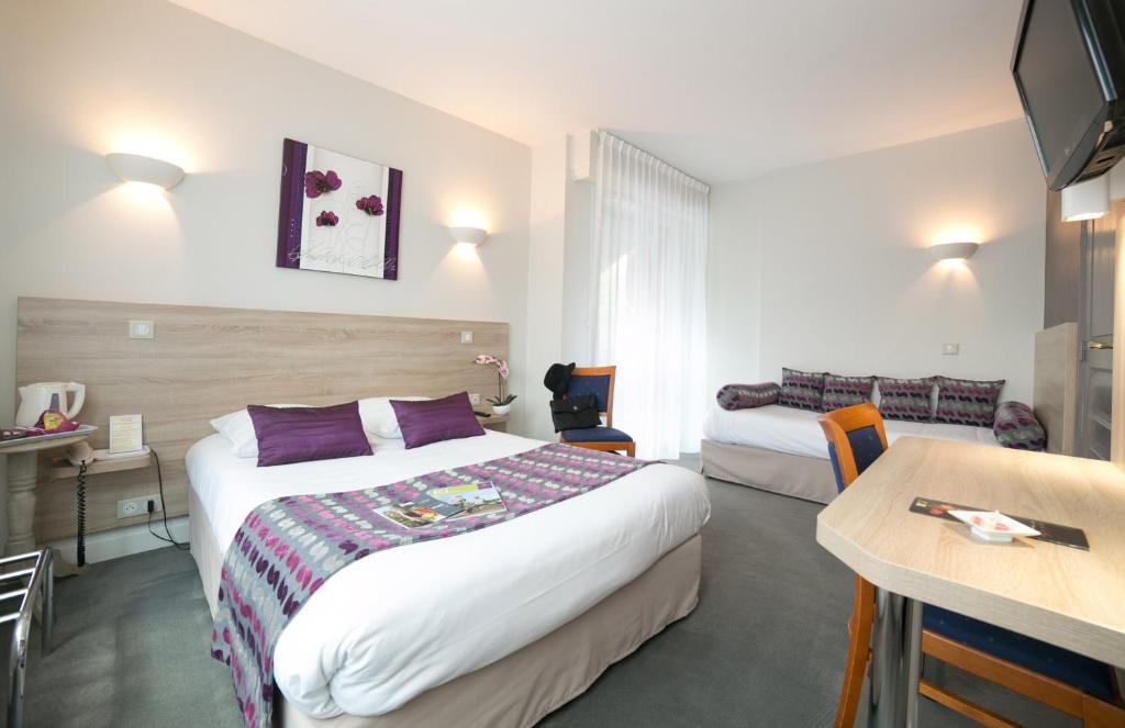 ein Hotelzimmer mit 2 Betten und einem Tisch in der Unterkunft Logis Auberge de la Rose in Doué-la-Fontaine