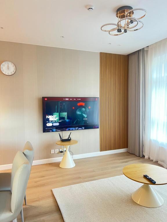 a living room with a flat screen tv on the wall at High-end, New, 2 Bedroom at primary location, every comfort you need in Ulaanbaatar