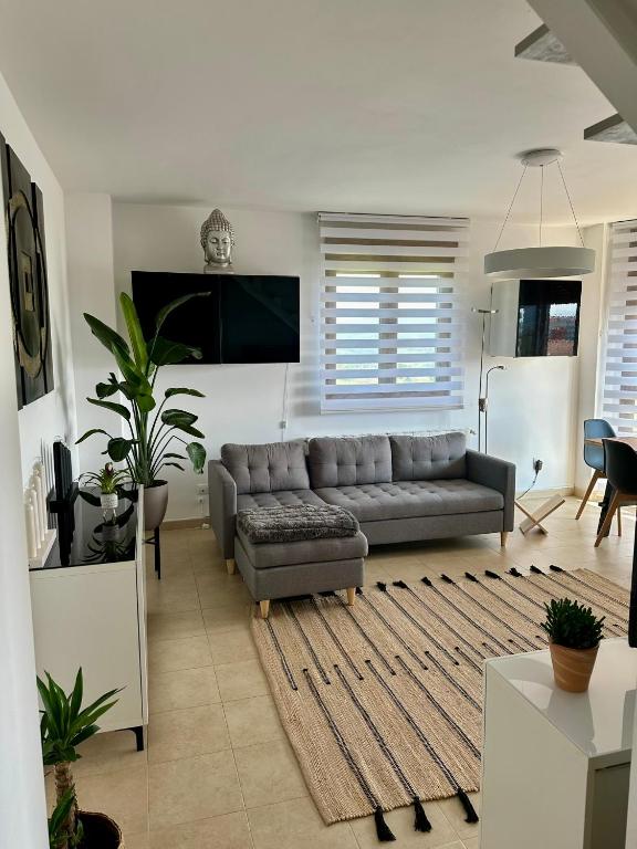 a living room with a couch and a flat screen tv at El Capricho de la Hayuela in Ayuela