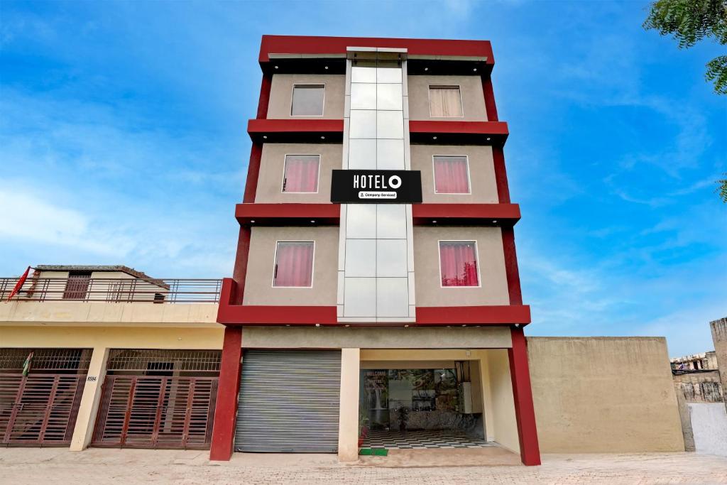 a tall red and white building with a sign on it at Super Hotel O Sector 52 Chandigarh Formerly Hari Residency in Chandīgarh