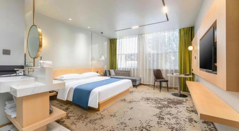 Postel nebo postele na pokoji v ubytování Borrman Hotel Jining High-tech Huangtun