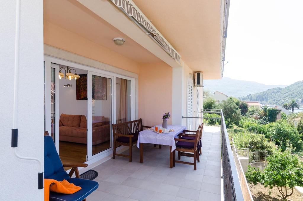 a balcony of a house with a table and chairs at Apartment Marela in Mokošica