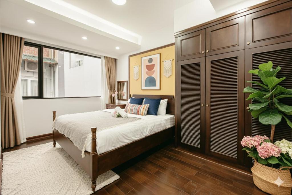 a bedroom with a bed and a large window at Lunaria Two Bedroom Apartment in Hanoi