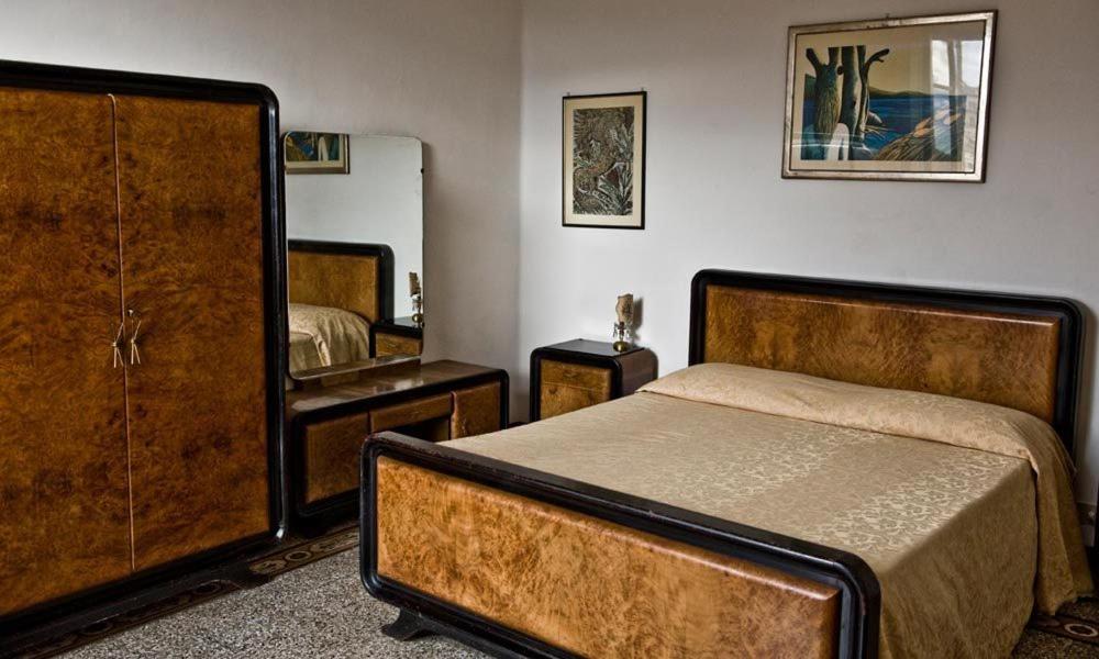 una camera con letto, cassettiera e specchio di Vicolo Dell'Oro a Siena