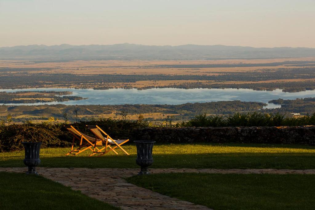 - deux chaises assises sur l'herbe près d'un lac dans l'établissement Hotel Nabia, à Candeleda