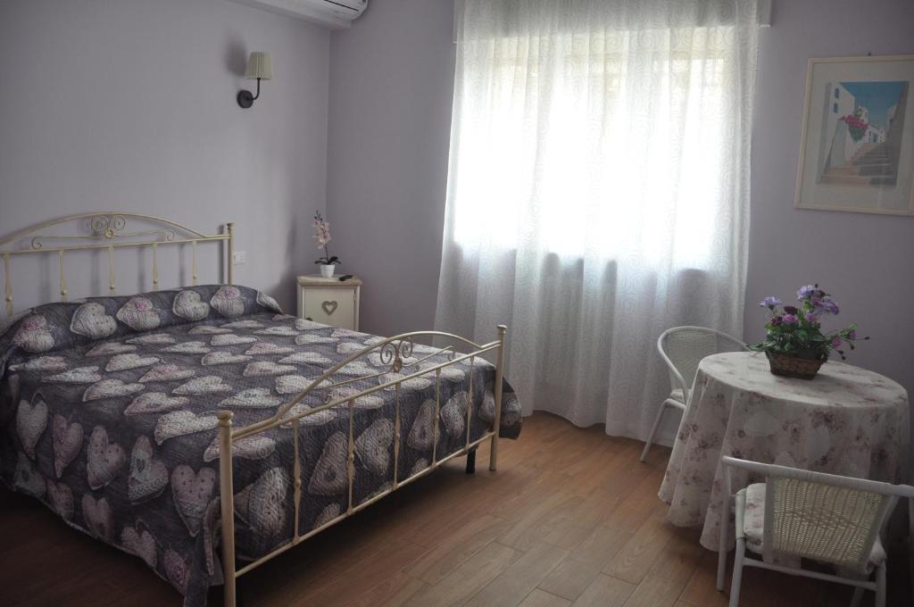 a bedroom with a bed and a table and a window at Casa Gioia in Taranto