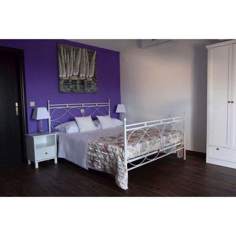 a bedroom with a bed with a purple wall at Apartments Sabioncello in Orebić