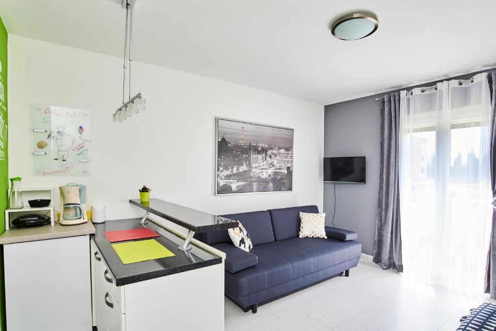 salon z niebieską kanapą i stołem w obiekcie Studio Apartment Vanda w mieście Umag