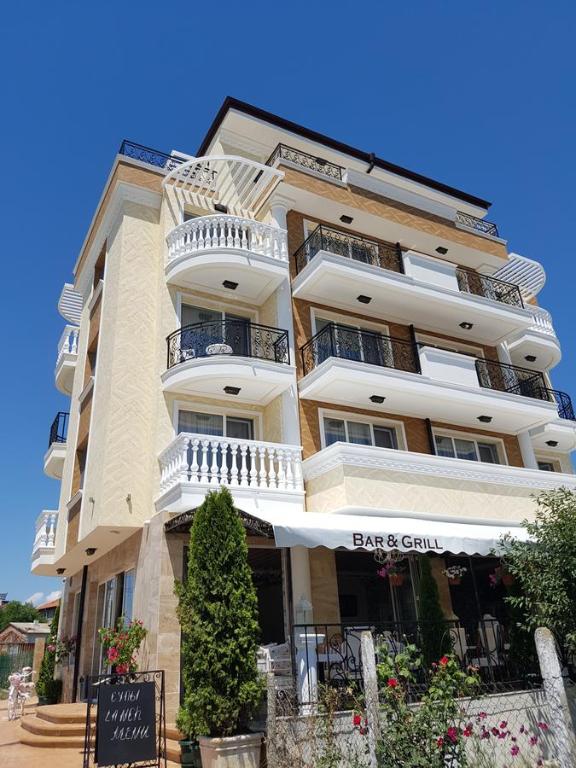 un edificio alto con un cartel delante en семеен хотел Прованс Ахелой en Aheloy