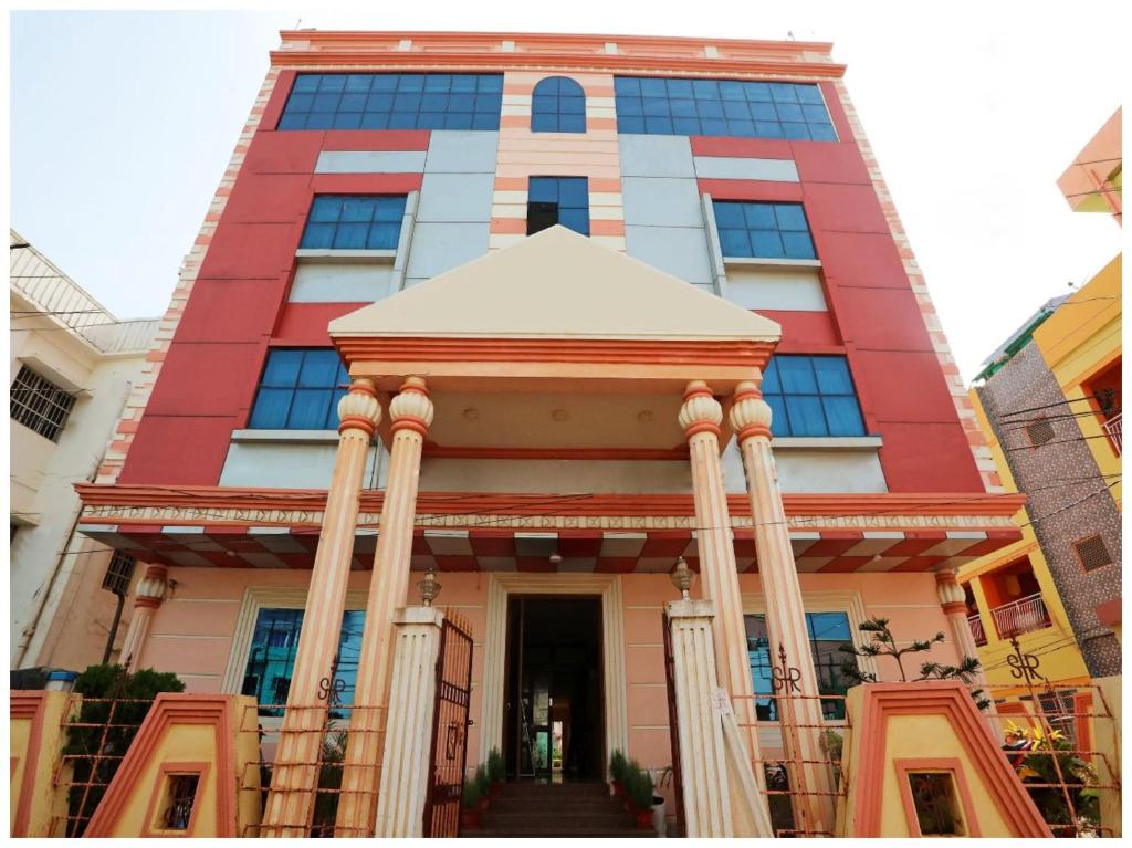 a tall building with columns in front of it at Hotel New Sambit International Near Sea Beach And Jagannath Temple in Puri